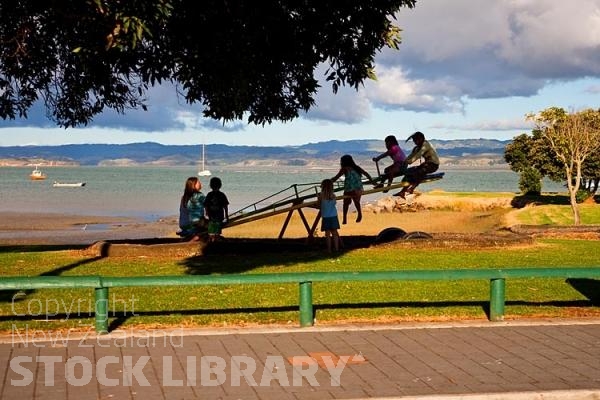 Kawhia;Waikato;coastal;bachs;holiday homes;bush;native forrest;blue sky;blue sea;boating;Fishing boats;Playing on the SeeSaw;Playing;SeeSaw;children playing;children;playing;beach;beach front