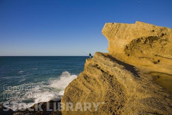 Castle Point;Wairarapa;Blue sea;blue sky;cumulus clouds;rocky shorelines;sandy beaches;scenic beauty;golden sands;bluffs;cliffs;lighthouse;fishermen;anglers;rocky outcrops;fishing boats;beach launched boats;Fisherman on Rocks