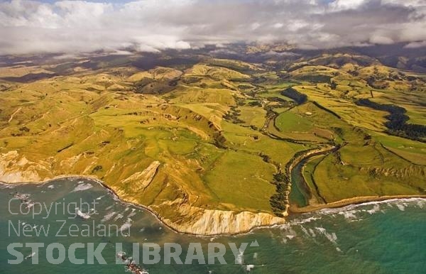 Aerial;Wairarapa Coast;Wairarapa;Blue sea;blue sky;cumulus clouds;rocky shorelines;sandy beaches;scenic beauty;golden sands;bluffs;cliffs;bush;native forrest;Kaiwhata River;Riversdale;rocky shorelines;hill country;sheep country;river mouth