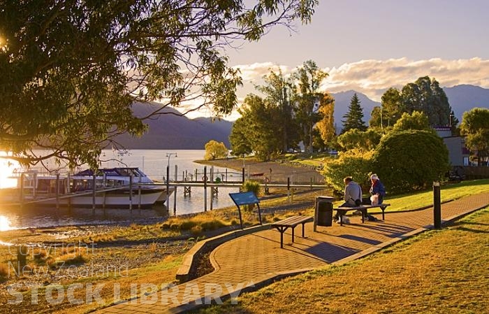 Lake Te Anau;Fiordland;mountains;hills;rivers;Road;State Highway 94;bush;native forrest;Te Anau;green fields;green paddocks;lakes;blue sky;Lake Front;jetty;pier;boat hire;boat tours;people on bench