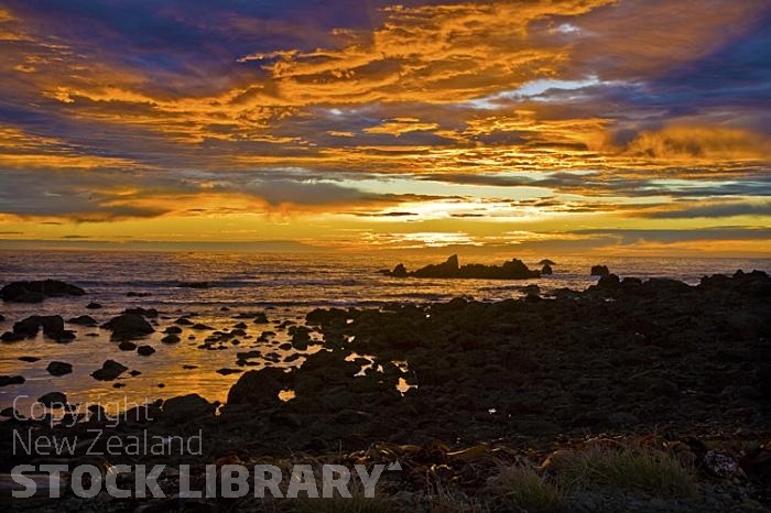 Kaikoura Coast;Kaikoura;bush;native forest;seaward Kaikoura Range;green fields;paddocks;brown hills;hills;mountains;rivers;ocean;pacific ocean;coast road;road;rail line;rocky shoreline;sea;Sun Rise;orange sky;orange clouds