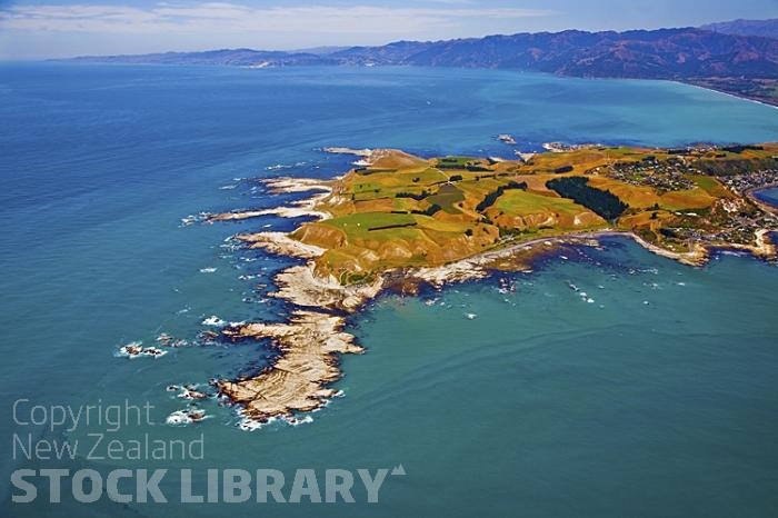 Aerial;Kaikoura;Kaikoura Peninsula;seaward Kaikoura Range;green fields;paddocks;brown hills;hills;mountains;ocean;pacific ocean;whale watch;seals;seal watch;blue sky;blue sea;rocky shoreline;Rail line;Station;rail Station;tourists