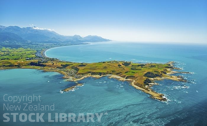 Kaikoura Peninsula;Aerial;Kaikoura;seaward Kaikoura Range;green fields;paddocks;brown hills;hills;mountains;ocean;pacific ocean;whale watch;seals;seal watch;blue sky;blue sea;rocky shoreline;Rail line;Station;rail Station;tourists;Kaikoura Peninsula