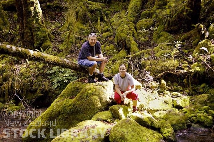 Bush;creek;Buller Region;lichen;moss;flowing water;stream;trampers;happy trampers;man tramper;woman tramper